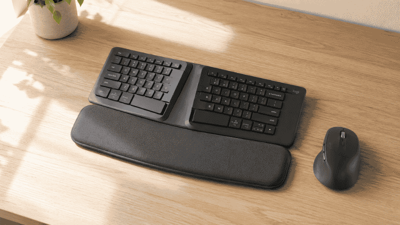 Ergonomic split keyboard on a clean home office desk with wrist rest and natural side lighting